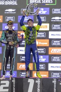 Arthur Gama ergue o troféu no alto do pódio após vencer a Night Challenge da NASCAR Brasil Series em Cuiabá, com Felipe Tozzo, segundo colocado, ao lado